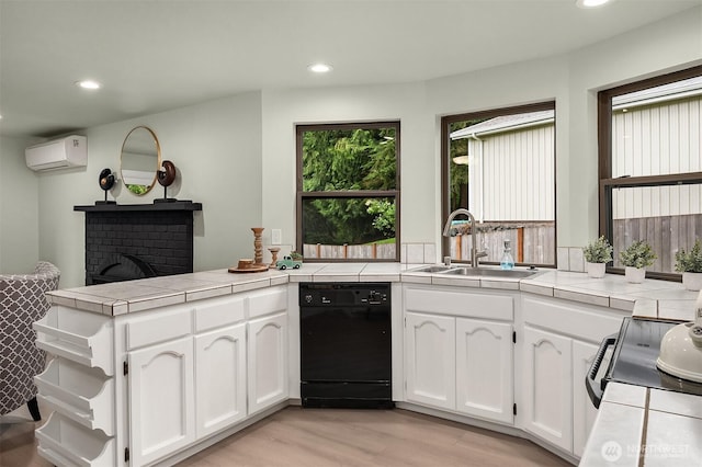 kitchen featuring tile counters, recessed lighting, a sink, and black appliances