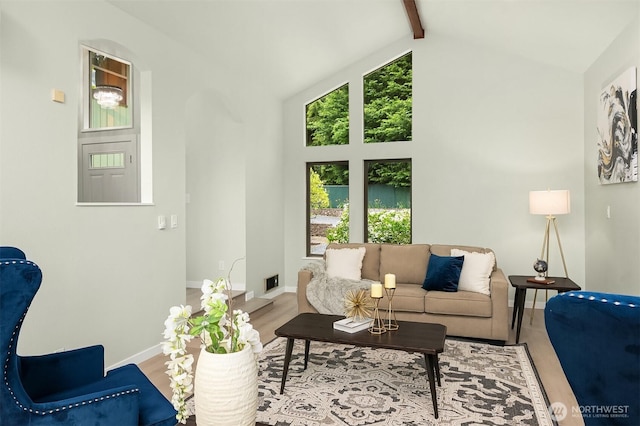 living area featuring wood finished floors, baseboards, beam ceiling, and high vaulted ceiling