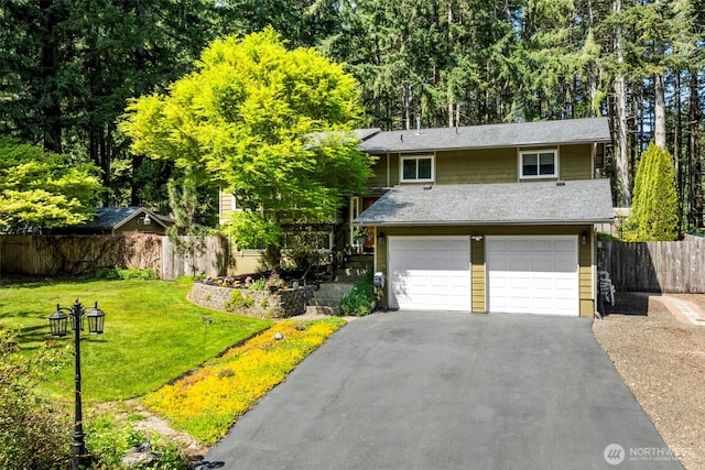 view of front of house featuring fence, roof with shingles, an attached garage, a front lawn, and driveway