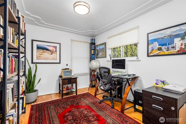 office space with baseboards and wood finished floors