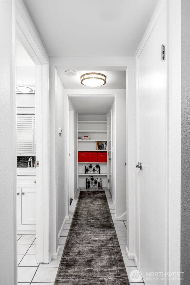 hallway with baseboards and light tile patterned floors