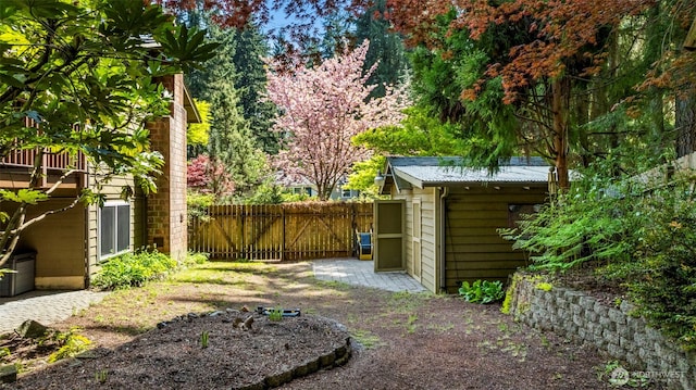 view of yard with a storage shed, fence, and an outbuilding