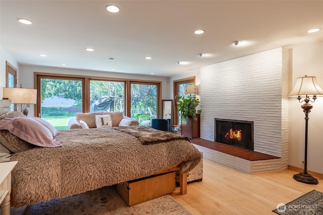 bedroom with a fireplace, recessed lighting, and wood finished floors