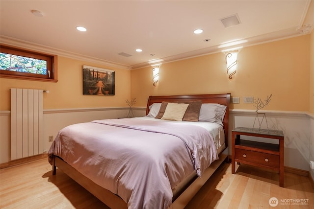 bedroom with radiator heating unit, ornamental molding, light wood-style floors, and recessed lighting