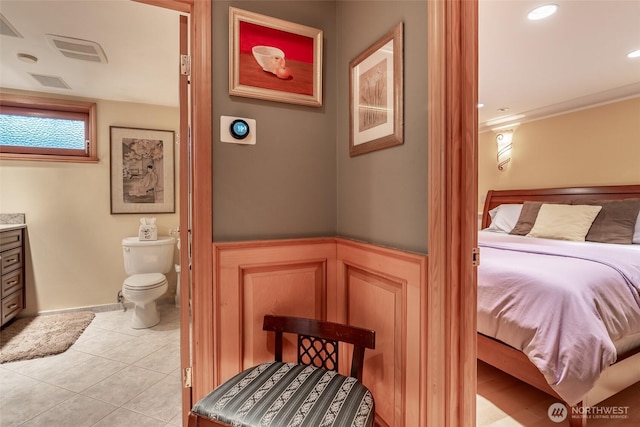 bedroom with visible vents, connected bathroom, and light tile patterned floors