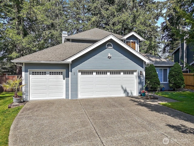 view of front of house with driveway, a chimney, fence, an attached garage, and a shingled roof