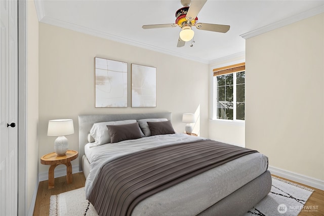 bedroom featuring crown molding, a ceiling fan, baseboards, and wood finished floors