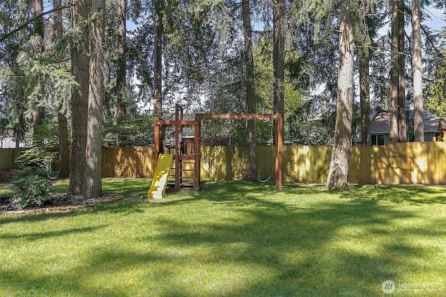 view of playground with a lawn and a fenced backyard
