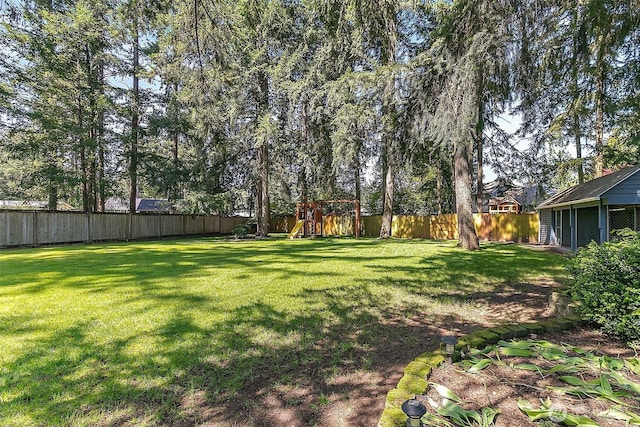 view of yard with a fenced backyard and a playground