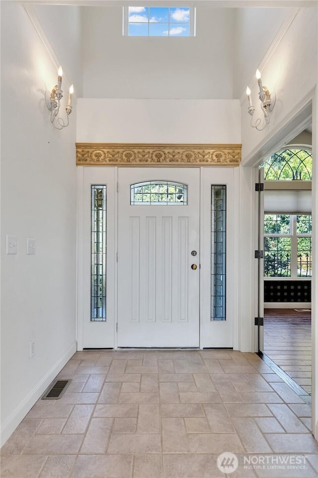 10910 48th Street Ct E, Edgewood, WA 98372 - foyer entrance featuring a towering ceiling, healthy amount of natural light, a chandelier, and light stone finish flooring