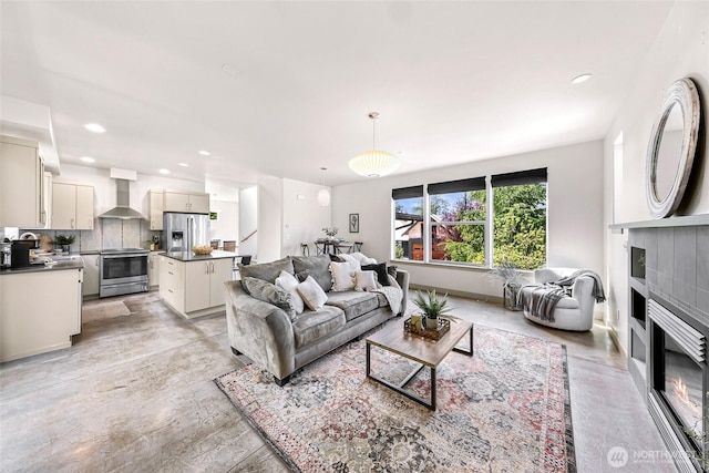 living room with a tile fireplace and recessed lighting