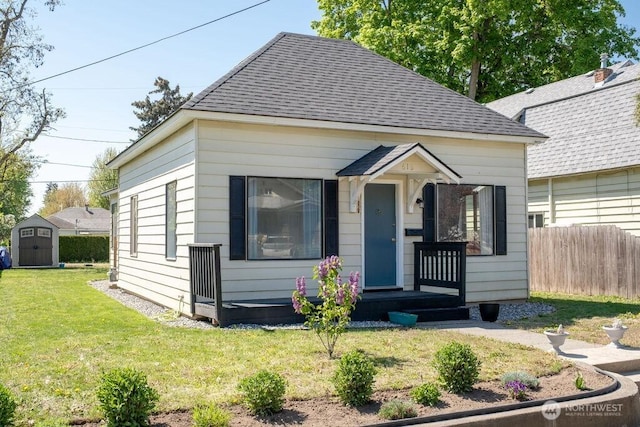 616 Pleasant St, Walla Walla, WA 99362 - bungalow featuring fence, a shingled roof, a front lawn, a storage shed, and an outdoor structure