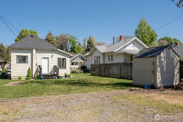 616 Pleasant St, Walla Walla, WA 99362 - back of house featuring an outbuilding, a yard, fence, and a storage shed