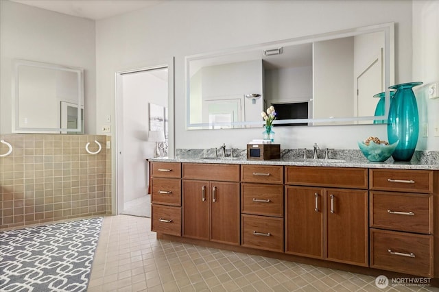 full bathroom featuring visible vents, a sink, tile patterned floors, and double vanity