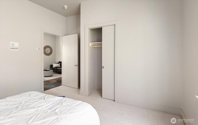 bedroom featuring light carpet and a closet