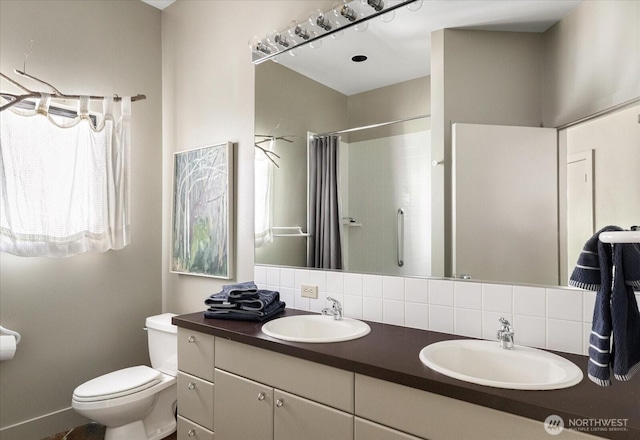bathroom featuring double vanity, toilet, a shower with curtain, and a sink