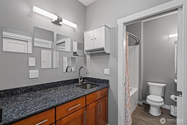 bathroom with wood finished floors, vanity, baseboards, toilet, and shower / bath combo with shower curtain