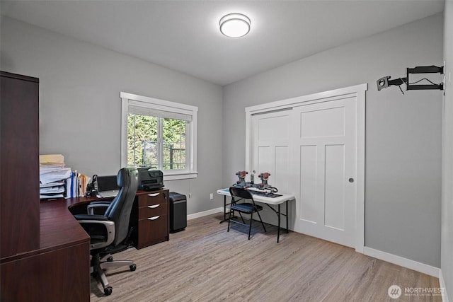 office space featuring baseboards and light wood finished floors