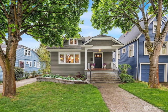 view of front of home featuring covered porch, roof with shingles, and a front lawn