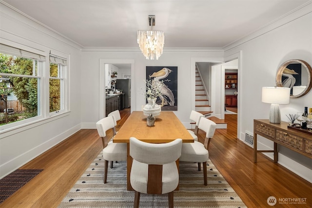 dining room with visible vents, dark wood-style flooring, a chandelier, and stairway