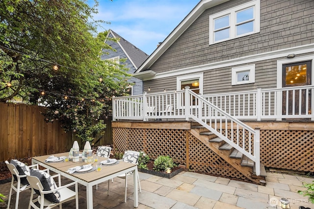 rear view of property with a patio area, fence, a deck, and outdoor dining space