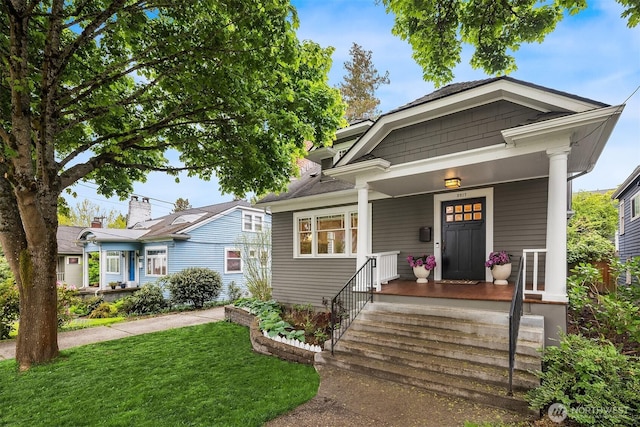 bungalow with a porch and a front lawn