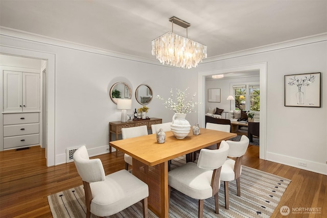 dining space with baseboards, a chandelier, dark wood-style floors, and visible vents