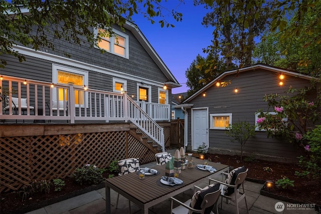 rear view of house with a wooden deck, a patio, and outdoor dining area