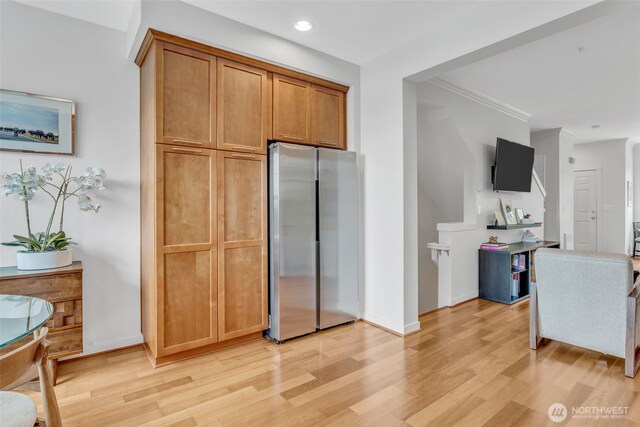 kitchen featuring light wood-type flooring, freestanding refrigerator, crown molding, and recessed lighting