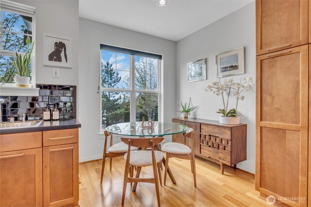 dining room with recessed lighting, light wood finished floors, and baseboards