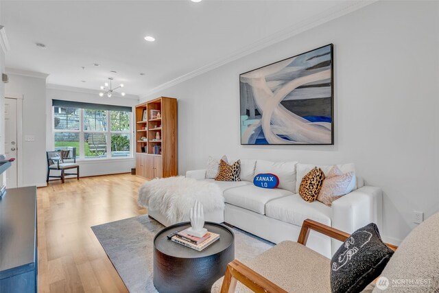 living room featuring recessed lighting, a notable chandelier, ornamental molding, and wood finished floors