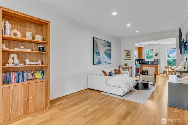 living area featuring crown molding and light wood-style flooring