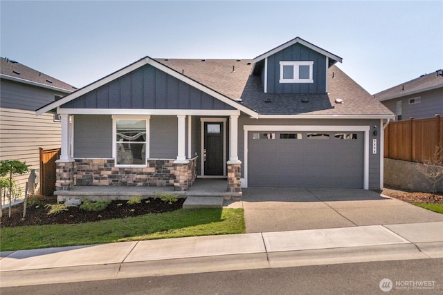 craftsman house with fence, a shingled roof, board and batten siding, a porch, and driveway