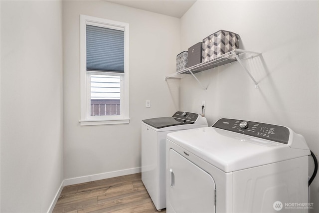 laundry area featuring laundry area, washing machine and dryer, baseboards, and light wood finished floors