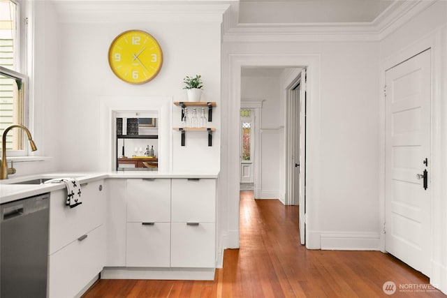 kitchen featuring a healthy amount of sunlight, ornamental molding, light wood-style flooring, and dishwasher