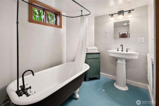 full bath with a shower with curtain, baseboards, a freestanding bath, and finished concrete flooring