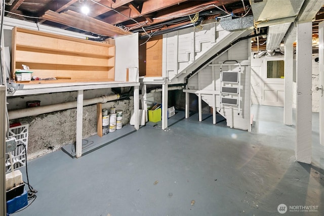 unfinished below grade area with stairs and a workshop area