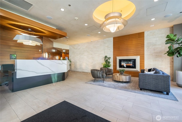reception with a glass covered fireplace and visible vents