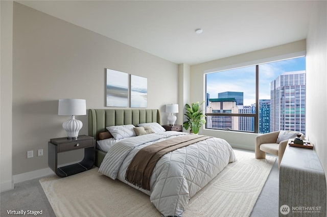 bedroom featuring carpet floors, a view of city, and baseboards