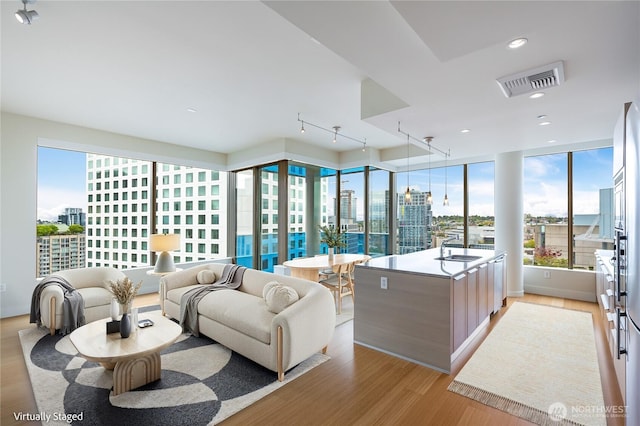 living area with a view of city, recessed lighting, visible vents, and light wood-type flooring