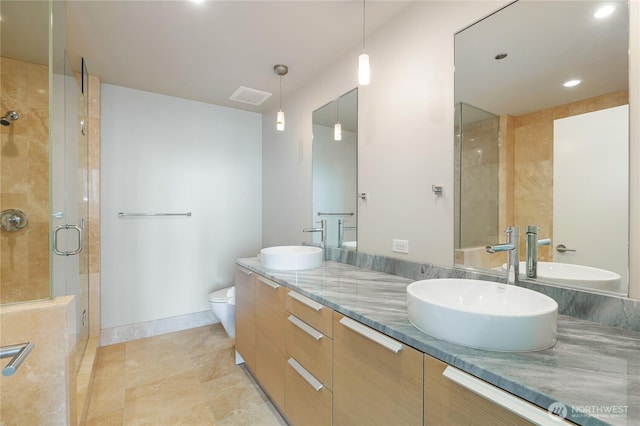 full bath featuring visible vents, a sink, and a shower stall
