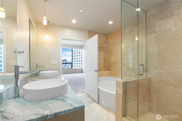 full bath featuring a garden tub, double vanity, recessed lighting, a shower stall, and a sink