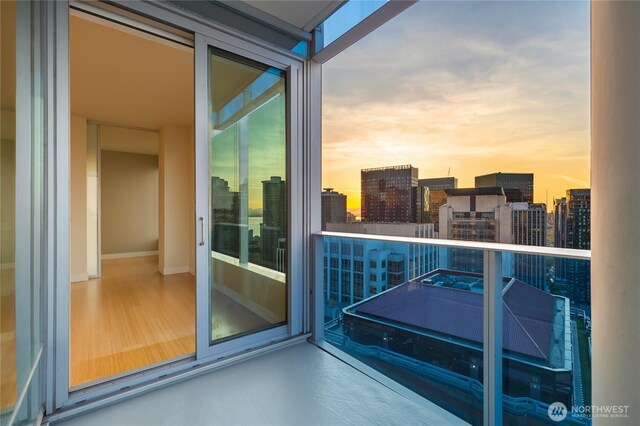balcony at dusk featuring a city view