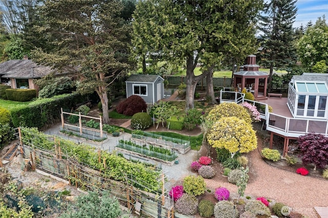 view of yard with an outbuilding, a vegetable garden, a gazebo, fence, and a storage unit
