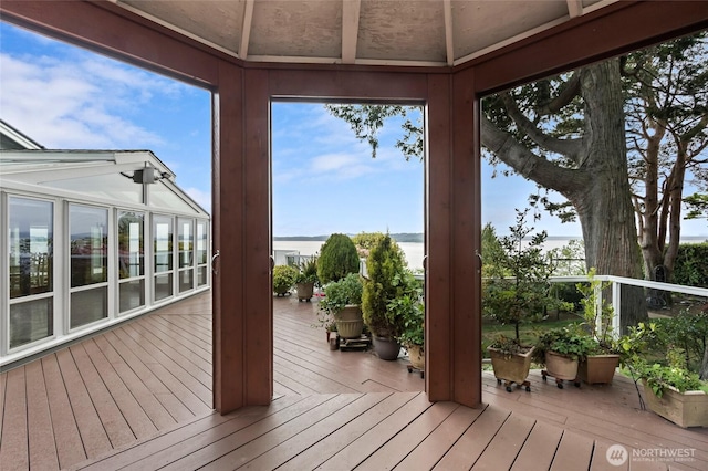 unfurnished sunroom with a deck with water view and hardwood / wood-style floors