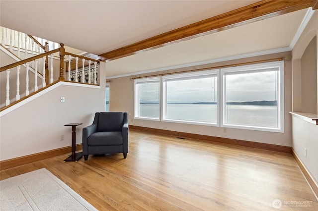 sitting room featuring light wood-style floors, baseboards, and stairway