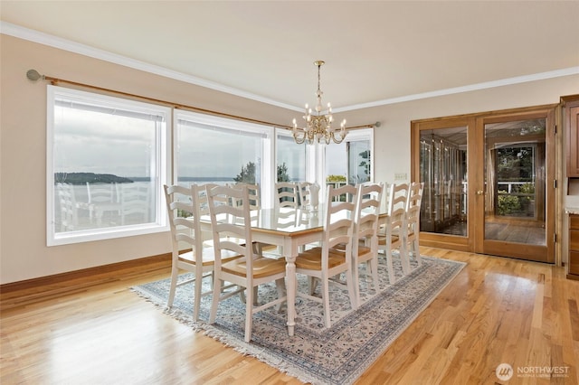 dining room with baseboards, a notable chandelier, ornamental molding, and light wood-style floors