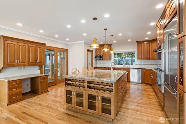 kitchen featuring light wood-style floors, appliances with stainless steel finishes, french doors, and brown cabinets