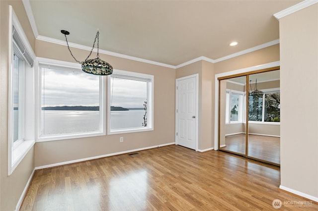 empty room featuring baseboards, recessed lighting, light wood-style flooring, and crown molding