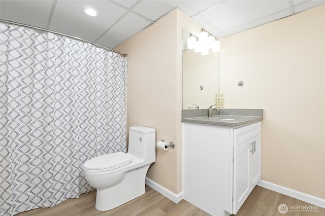 bathroom featuring vanity, baseboards, wood finished floors, and toilet